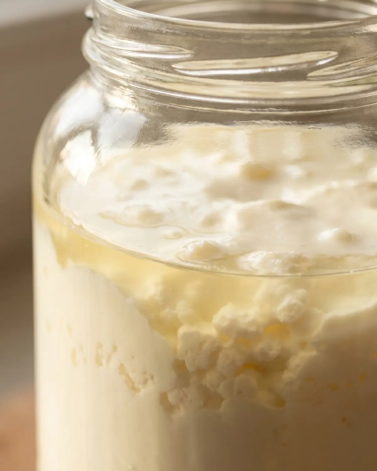 bere kefir la sera Primo piano del kefir nel barattolo, con la linea visibile tra siero più liquido e parte cremosa.